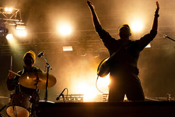Promotional image with a musician praising