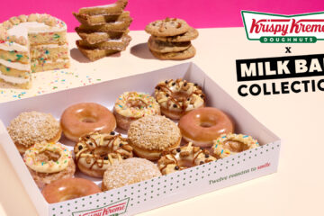 Box of assorted Krispy Kreme Milk Bar donuts in a white tray, with cakes and cookies in a pink studio backdrop.