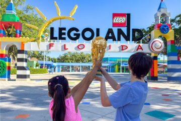 Promotional photo for Legoland FIFA World Cup showing kids holding up the FIFA trophy