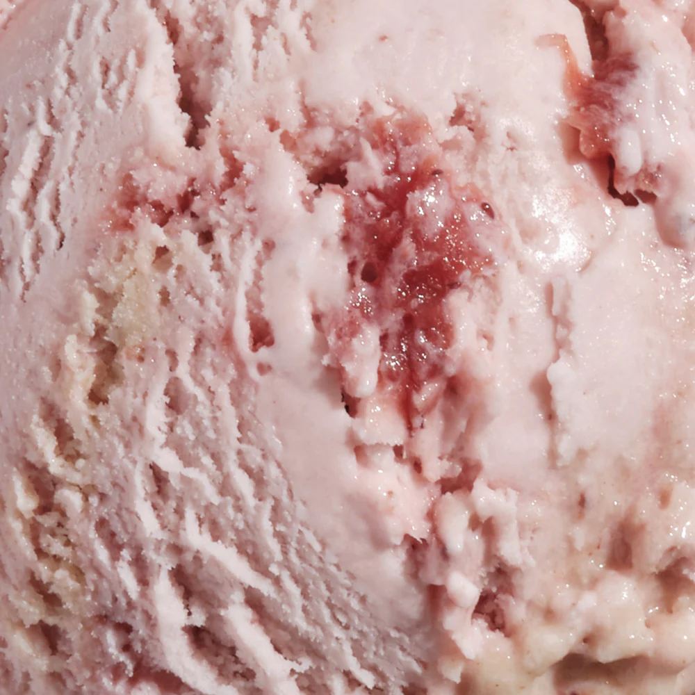 Close-up of pink strawberry ice cream with visible berry swirls and creamy texture.