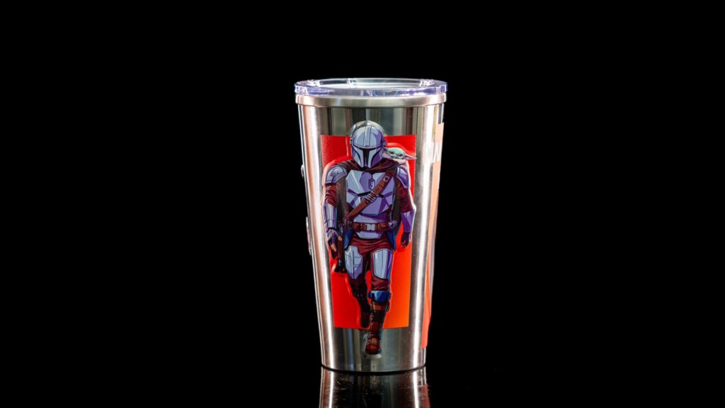 Stainless steel tumbler with a red sticker of Mandalorian and Grogu on a black background