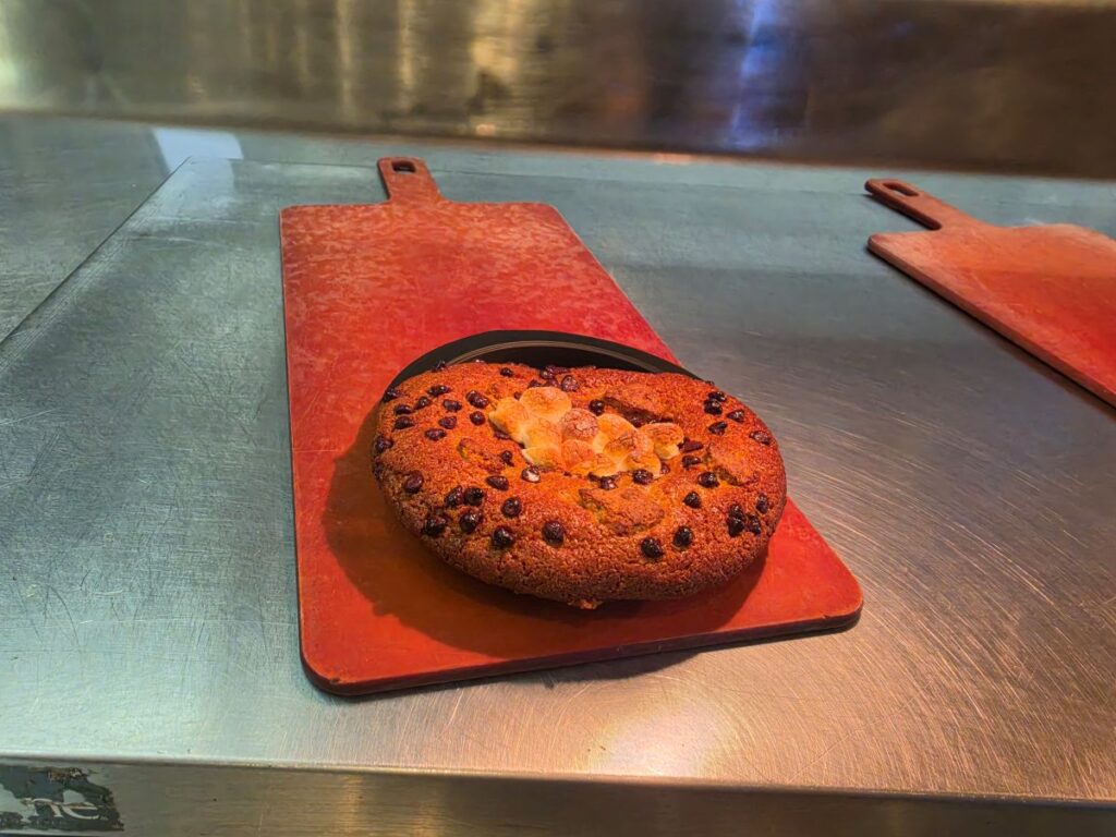 Round Café 4 S'mores Cookie on a red cutting board in a metal kitchen.