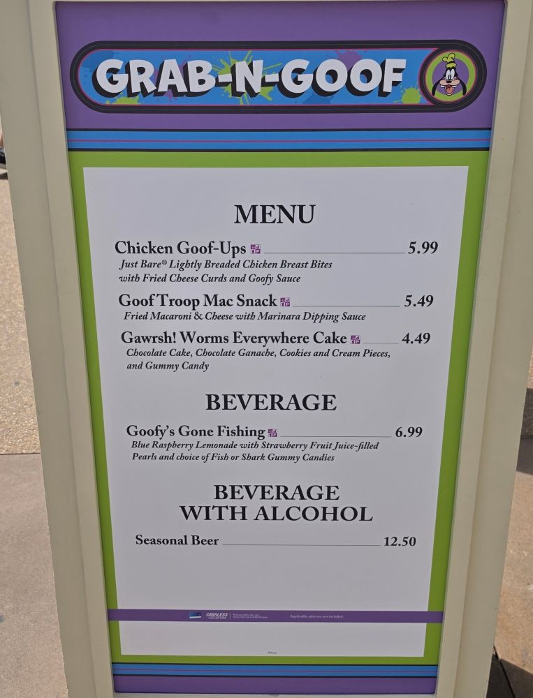 Signboard menu for 'Grab-N-Goof' showing the word MENU and listed items with prices (Chicken Goof-Ups $5.99, Goof Troop Mac Snack $5.49, Gawrsh! Worms Everywhere Cake $4.49; Beverages $6.99; Seasonal Beer $12.50).