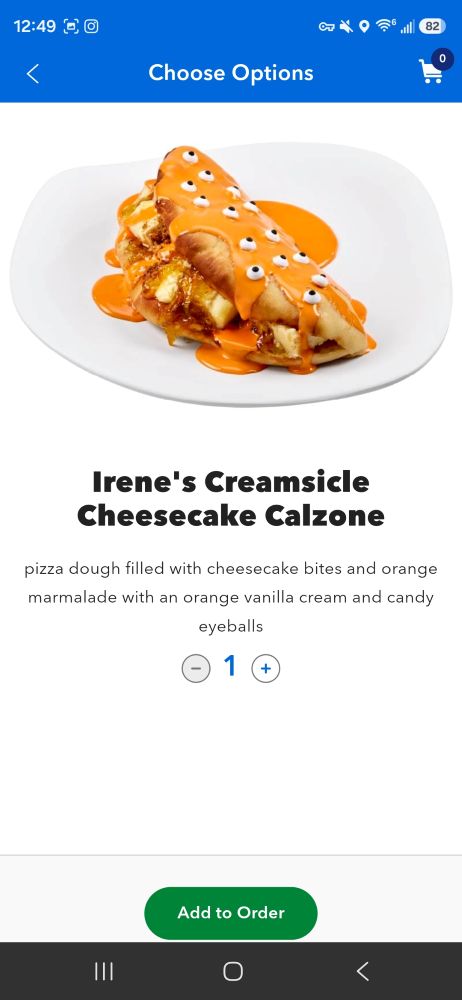 Irene's Creamsicle Cheesecake Calzone on a white plate, drizzled with orange sauce and candy eyeballs.