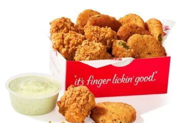 Red box of KFC fried pickles, plus a cup of creamy dipping sauce on the side.