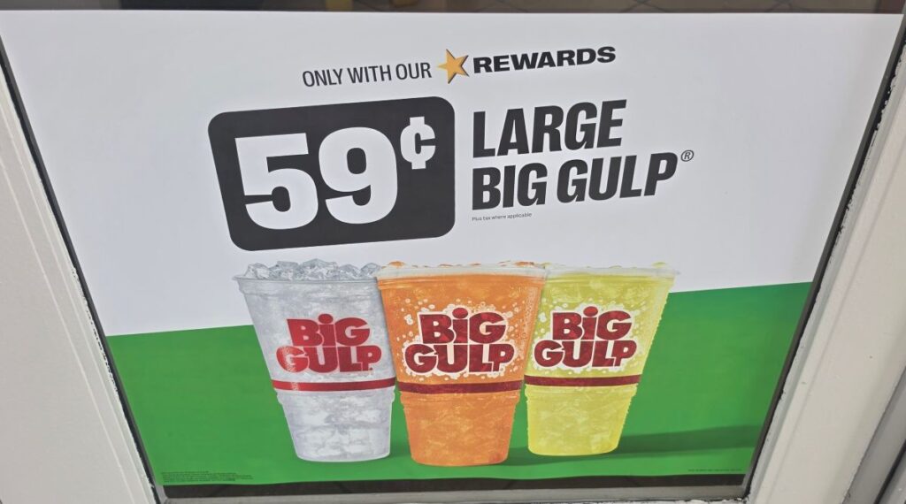 Promotional poster for 59¢ Large Big Gulp featuring three colorful cups on a green and white background, highlighting the Speedway drink deals price.