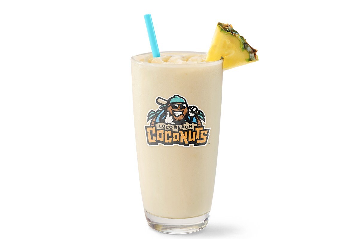 Tall glass of Loco Beach Colada Smoothie with pineapple–coconut smoothie with a blue straw and pineapple wedge, featuring the Loco Beach Coconuts logo on the cup.