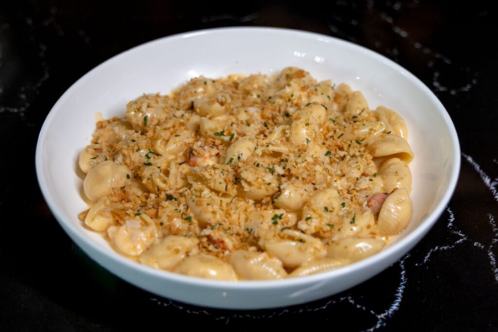 Creamy cheese tortellini in a white bowl, topped with crunchy breadcrumbs and chopped parsley