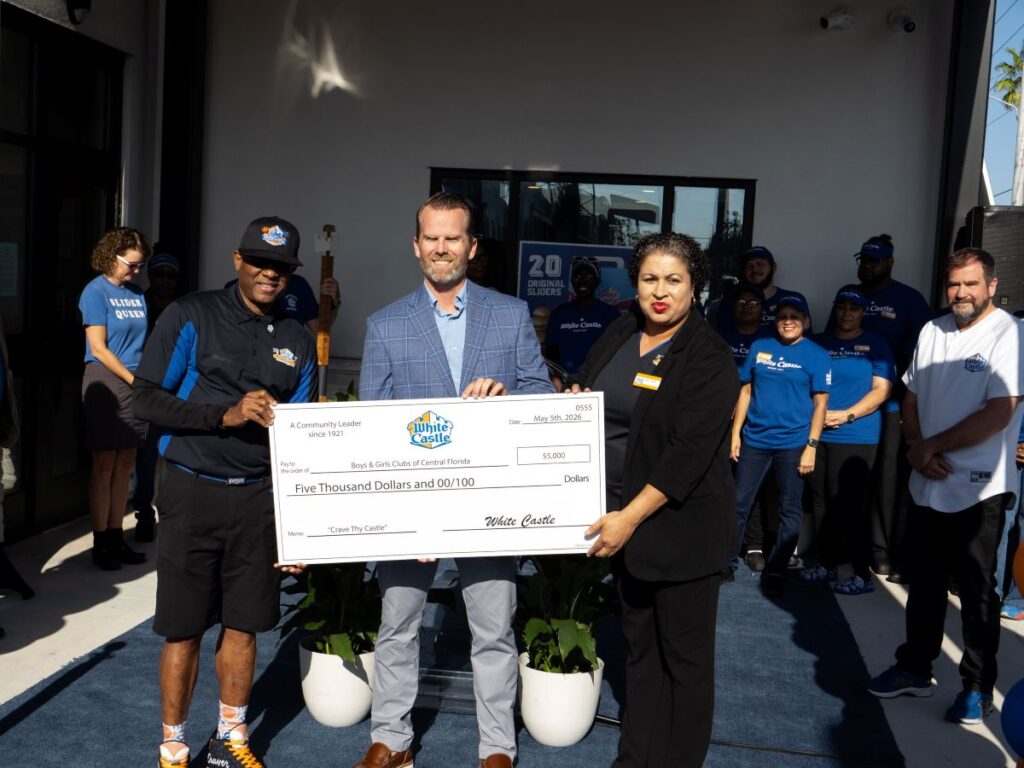 Group of people at a donation ceremony holding a large ceremonial check for $5,000 from White Castle to Boys & Girls Clubs of Central Florida, outdoors.