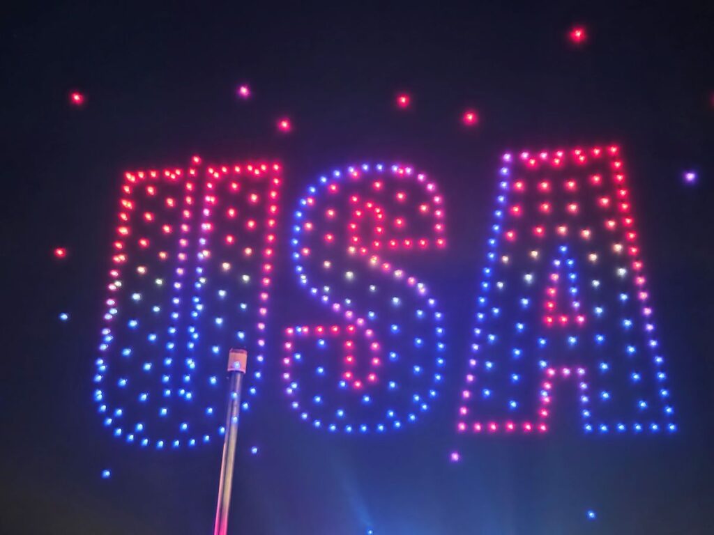Colorful LED light display forming the "USA" against a dark sky for Summer Nights 2026