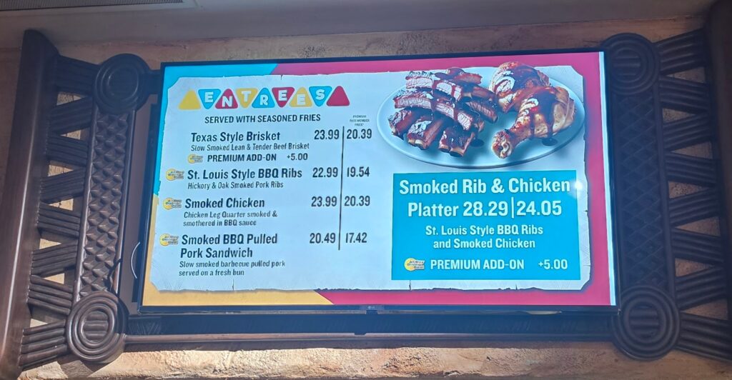 Barbecue menu board highlighting a Smoked Rib & Chicken Platter with prices and a plate of ribs on the right side.