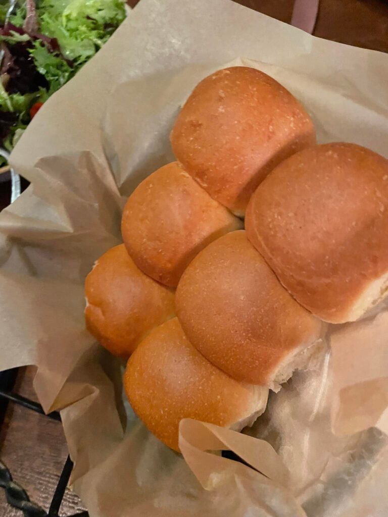 Pile of soft golden dinner rolls, ready to serve. eaten during our Liberty Tree Tavern review