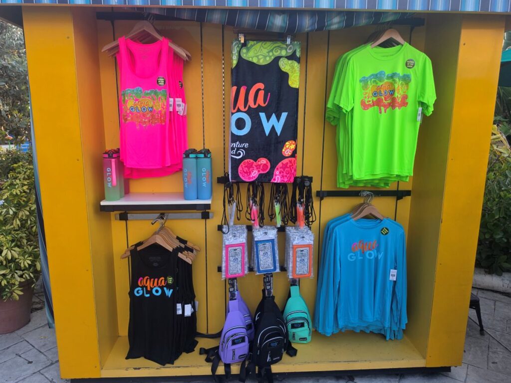 AquaGlow Adventure Island Tampa merchandise display with shirts, towels, and cups