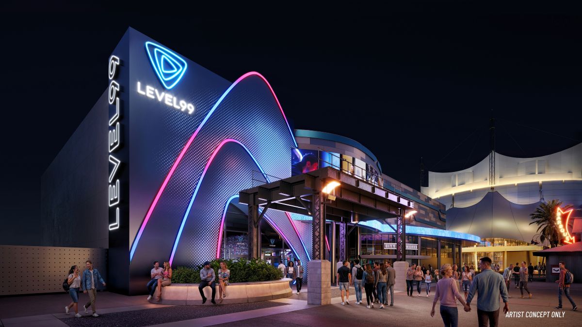 An artist's concept rendering of the Level 99 Disney Springs exterior at night, showing a modern, dark building facade illuminated with bright neon blue and pink geometric arches. The words "LEVEL 99" are displayed in glowing white text, running vertically down the side and horizontally beneath a triangle logo. People are depicted walking along the illuminated outdoor pathway and sitting on a low stone wall beneath an industrial-style awning.