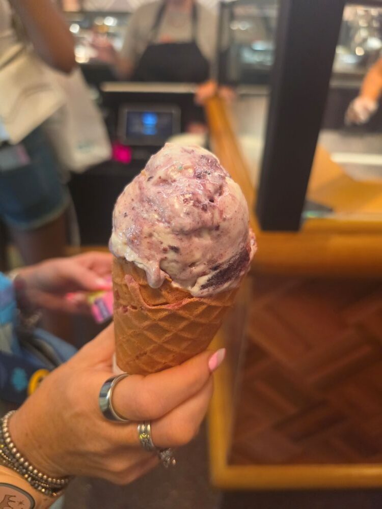 Salt & Straw Berries Series- woman holding a cone of Birthday Cakes and Blackberries flavor