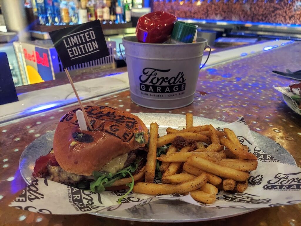 Highway 101 Burger with fries shown in front of Ford's Garage bucket