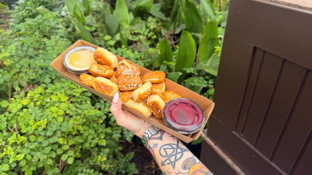 Bluey Pretzel Review: a hand showing Pretzel's Pretzels with the two dipping sauces in cups