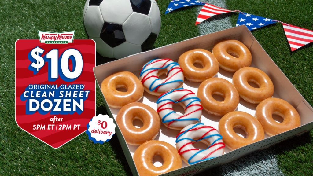 A Krispy Kreme soccer deal 5 PM2 PMpromotional graphic on a grass background featuring a soccer ball and a box of Krispy Kreme doughnuts. A red sign reads "$10 Original Glazed Clean Sheet Dozen after 5PM ET / 2PM PT" with a "$0 delivery" badge. The box contains 9 Original Glazed doughnuts and 3 doughnuts topped with white icing and red and blue stripes.