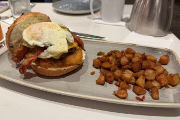 Sreakhouse 71 Breakfast Burger shows open-faced with potatoes on the side
