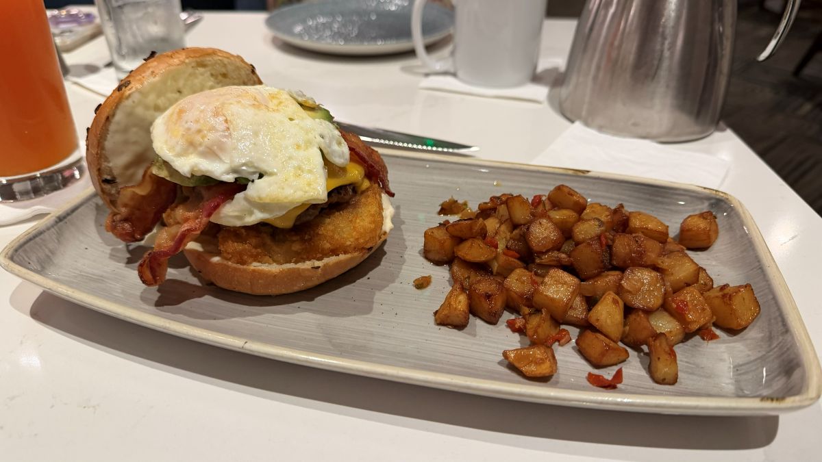 Sreakhouse 71 Breakfast Burger shows open-faced with potatoes on the side