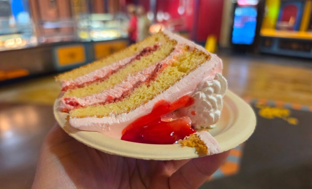 Busch Gardens Strawberry Shortcake on a white plate held up in the middle of Dragon Fire Grill