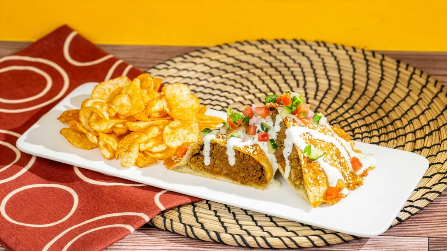 Harambe Market Menu update promotional photo showing the Tanzanian Meat Pie with chips