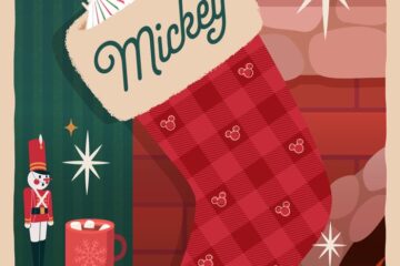 A charming holiday scene from Disney World holiday events featuring a red-and-pink checkered stocking labeled "Mickey" hanging by a fireplace. A cheerful reindeer character peeks out from inside, next to a small table holding a nutcracker, a mug of hot cocoa, and festive treats.