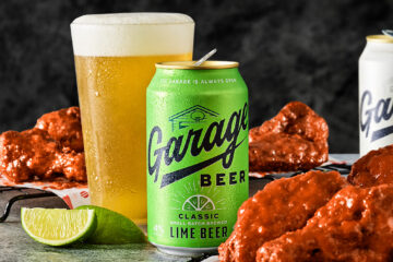 An informal garage atmosphere with various beer bottles and a large plate of chicken wings, perfect for a relaxed get-together for the Red Robin Garage Beer collaboration