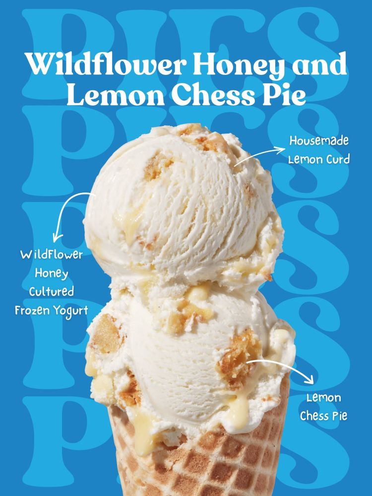 A Salt & Straw Summer Pies Series waffle cone stacked with two scoops of Wildflower Honey and Lemon Chess Pie ice cream set against a blue backdrop. Arrows annotate the wildflower honey cultured frozen yogurt base, drizzles of housemade lemon curd, and chunks of lemon chess pie.