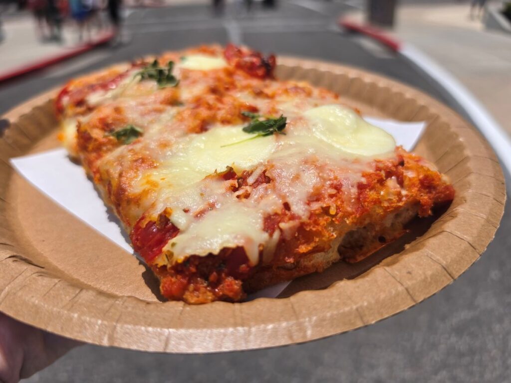 Close-up shot focusing on the golden, melted cheese and tomato toppings on a flatbread slice from TODAY Cafe.