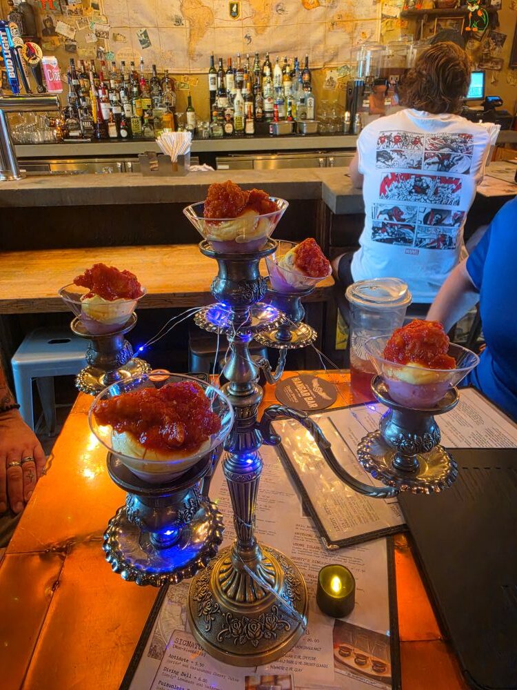 Full view of Candelabra Eggs served in martini glasses arranged on a tall metal candelabra at Jock Lindsey's Hangar Bar.