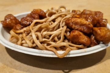 Crispy glazed orange chicken served alongside lo mein noodles at Dragon Fire Grill
