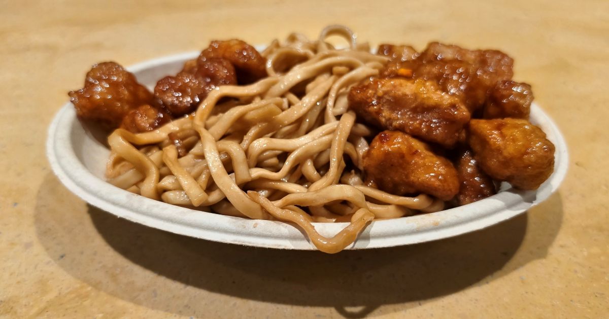 Crispy glazed orange chicken served alongside lo mein noodles at Dragon Fire Grill