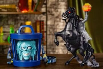 A blue cylindrical Halloween Party popcorn bucket featuring a light-blue skull face and a headless horseman figure on a black horse holding a glowing orange pumpkin head.