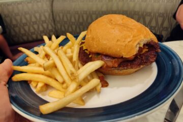 A Chili Impossible Burger with a side of french fries served on a blue-rimmed plate at The Plaza Restaurant.