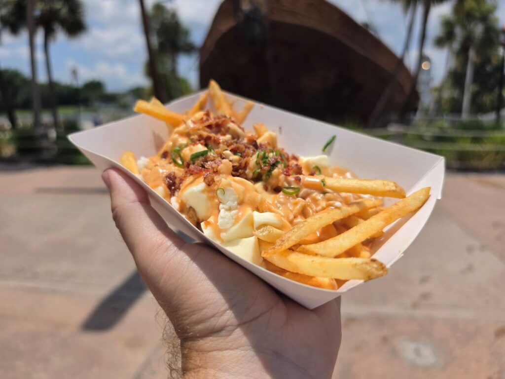 Loaded Crab Fries topped with cheese, bacon, and green onions served in a paper boat at Hurricane Hanna's