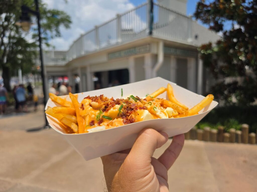 Close-up view of Loaded Crab Fries topped with crab meat, warm cheese, and bacon from Hurricane Hanna's