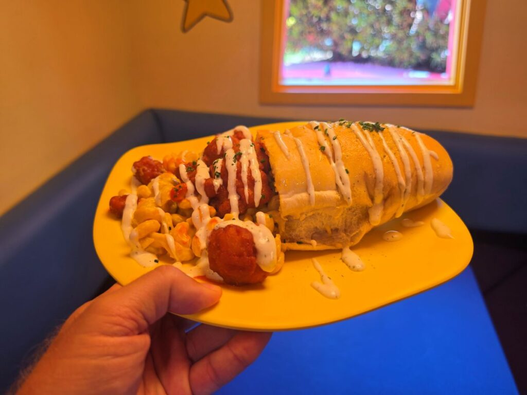 Plated Morris's Mac-nificent Mac and Cheese Cone featuring bread cone stuffed with macaroni and buffalo chicken on a table at Circus McGurkus Cafe.