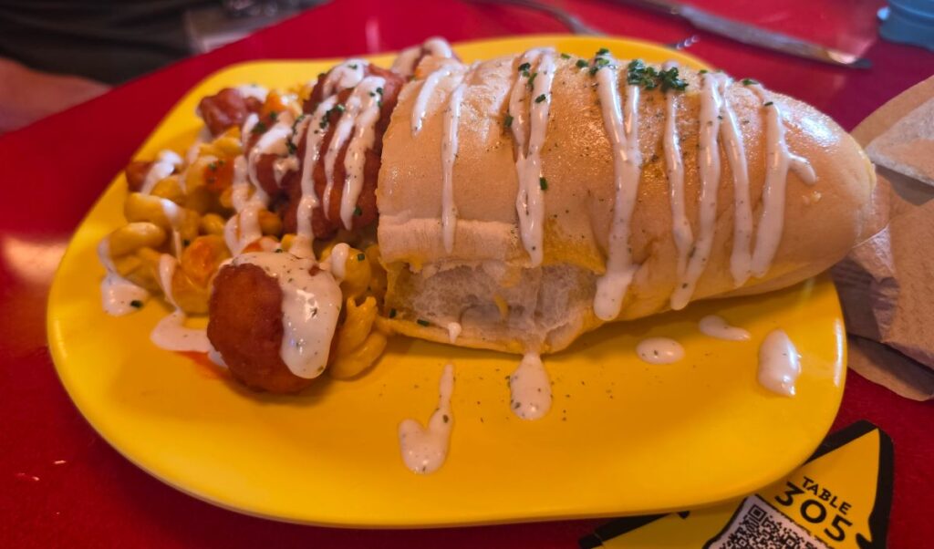 Plated Morris's Mac-nificent Mac and Cheese Cone featuring bread cone stuffed with macaroni and buffalo chicken on a table at Circus McGurkus Cafe.