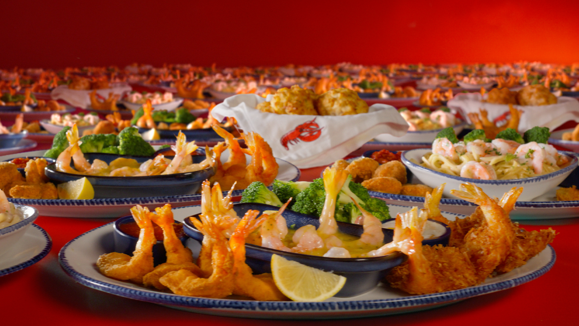 Plates of Red Lobster Ultimate Endless Shrimp featuring fried shrimp, scampi, pasta, broccoli, and Cheddar Bay Biscuits.