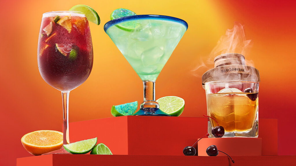 A line-up of Red Lobster cocktails including sangria with fresh fruit, a margarita, and a smoked bourbon drink.