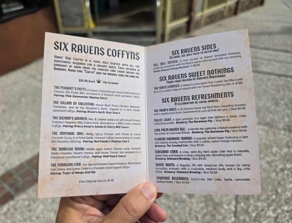 Open interior of the Six Ravens paper menu listing stuffed hand pie "Coffyns," sides, desserts, local beers, and refreshments with descriptions and pricing.