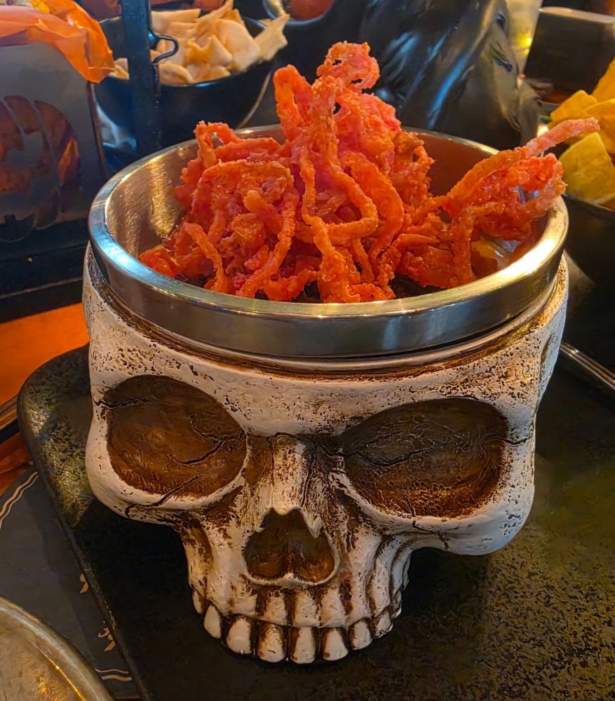 Close-up view of the Skull of the Dead Dip featuring barbacoa beef and crispy fried onions served inside a detailed skull container.