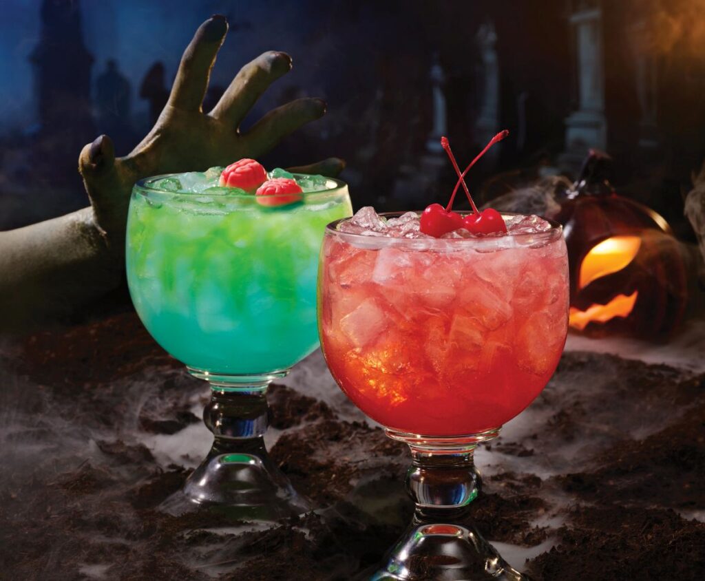 Applebee's $6 Mucho Halloween Spooky Sips cocktails featuring the green Tipsy Zombie topped with gummi brains and the red Dracula's Juice garnished with maraschino cherries.