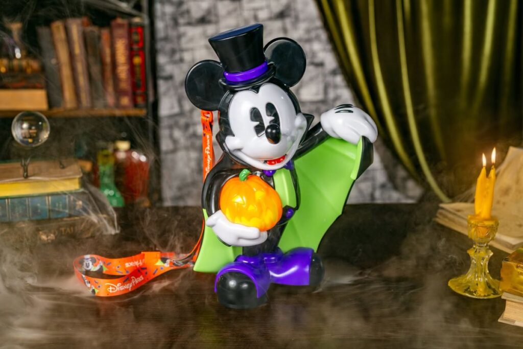 Mickey Mouse popcorn buckey with a vampire costume with a top hat, green-lined cape, and glowing jack-o'-lantern