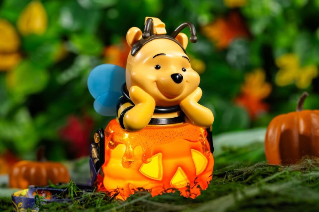Disney Halloween drink sipper featuring Winnie the Pooh in a honeybee costume sitting atop a glowing orange jack-o'-lantern honey pot