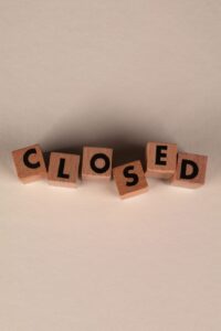 wooden blocks spelling closed on neutral background