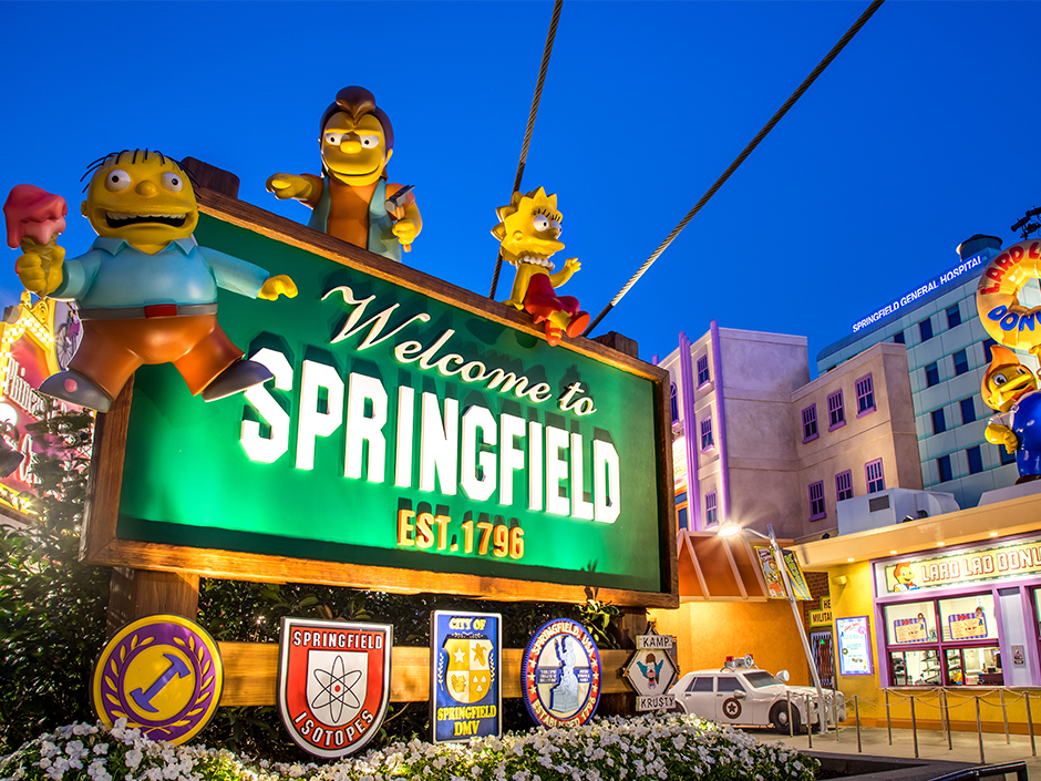 Illuminated Welcome to Springfield sign featuring Ralph Wiggum, Nelson, and Lisa at Universal Studios.
