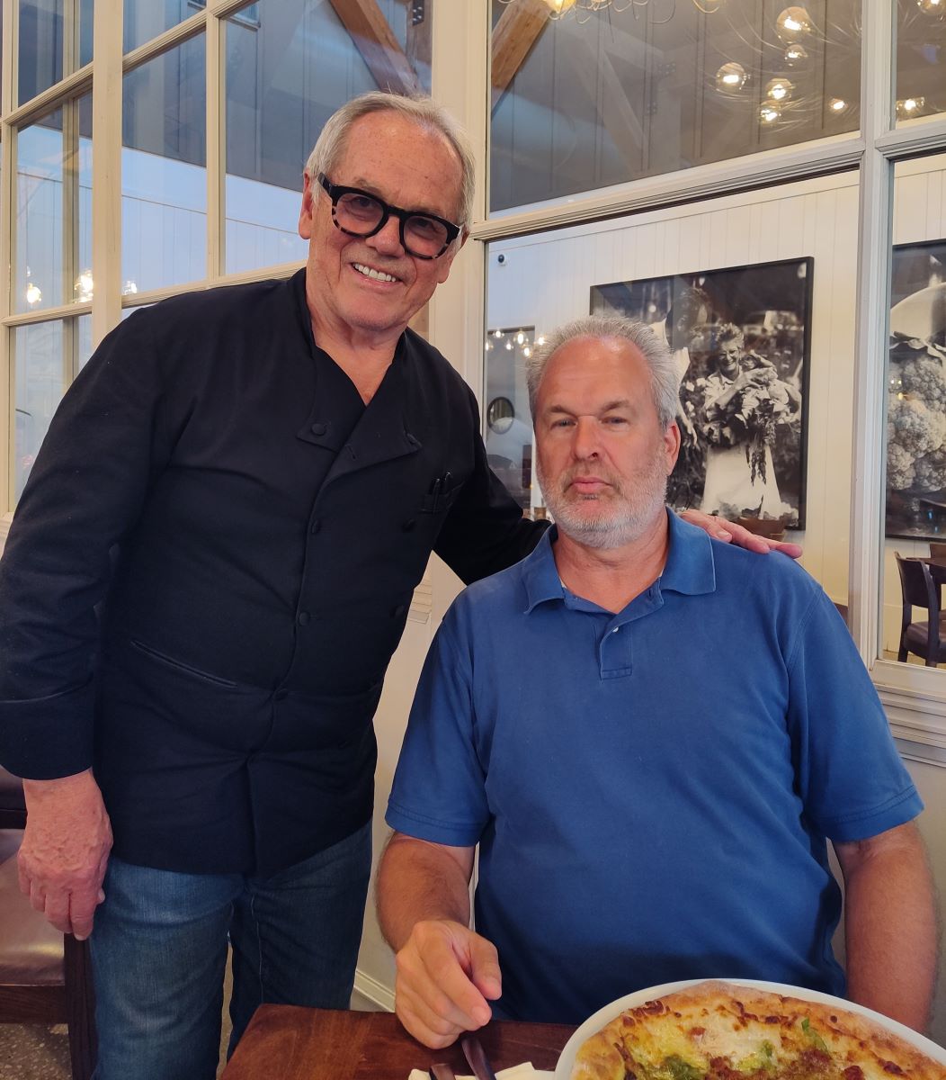 Wolfgang Puck and Jon Self taking a photo together inside the restaurant