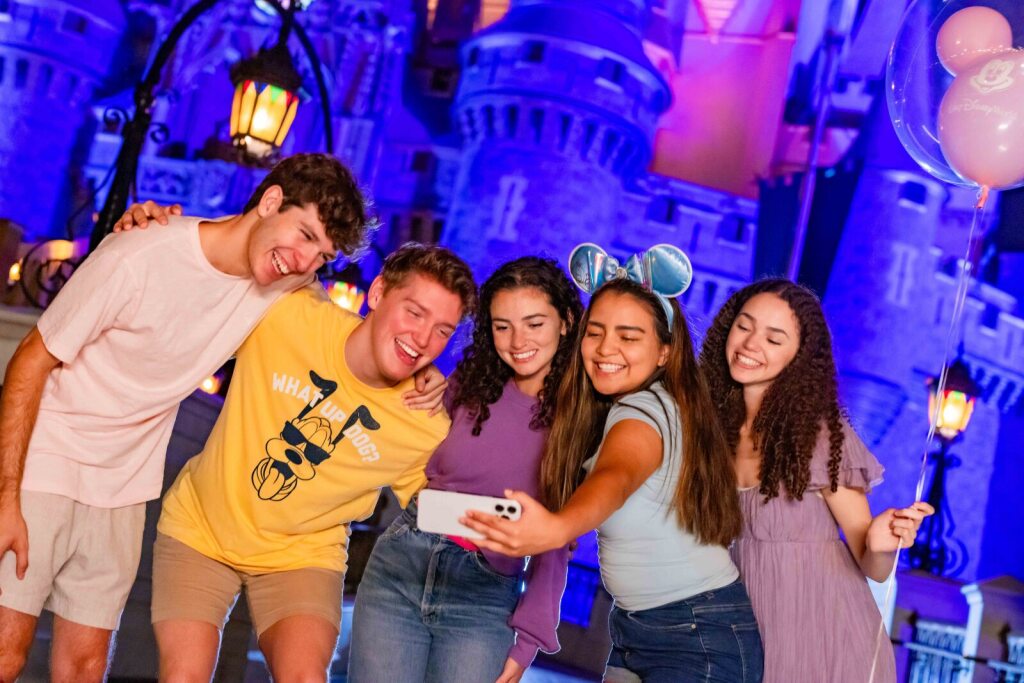 Guests taking a photo in front of the castle at Magic Kingdom, promoting 2027 Disney After Hours